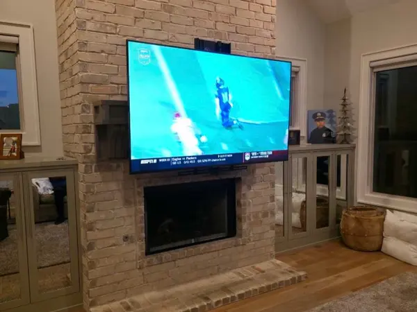TV mounted above a brick fireplace